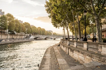 Quais de Seine à Paris au coucher du soleil avec des promeneurs